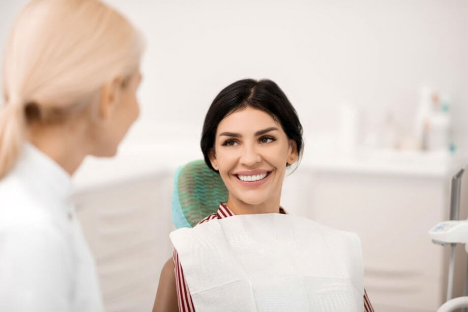female patient smiles at doctor from dental chair