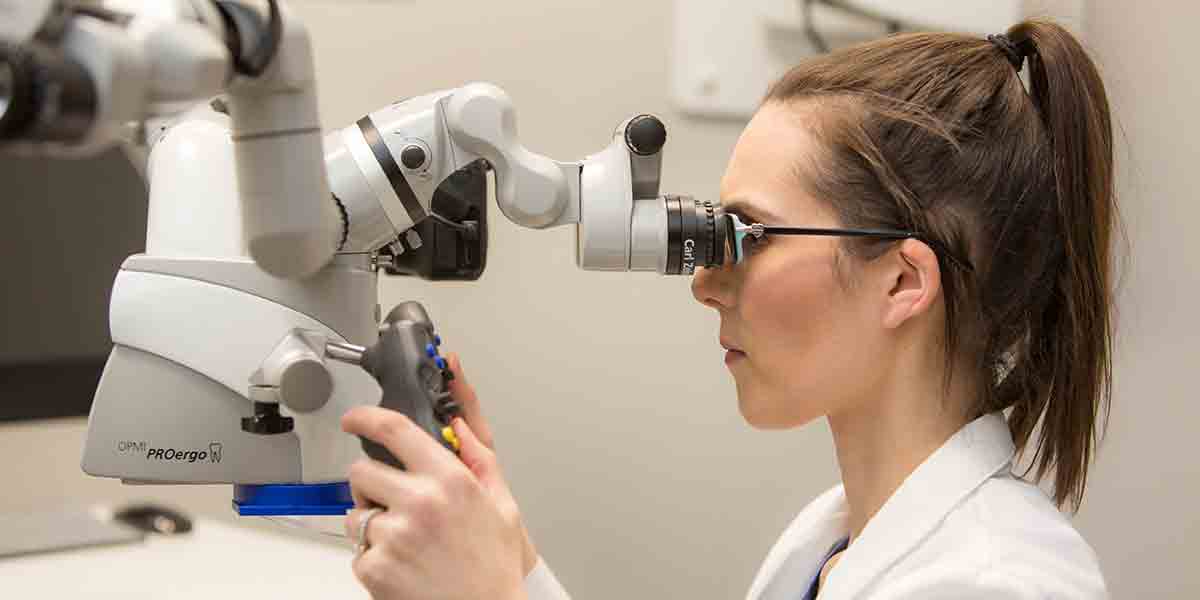 Dr. Victoria J. Ball using Dental Microscope